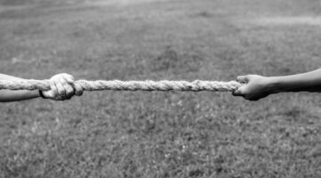 Closeup of hand pulling the rope in tug of war game